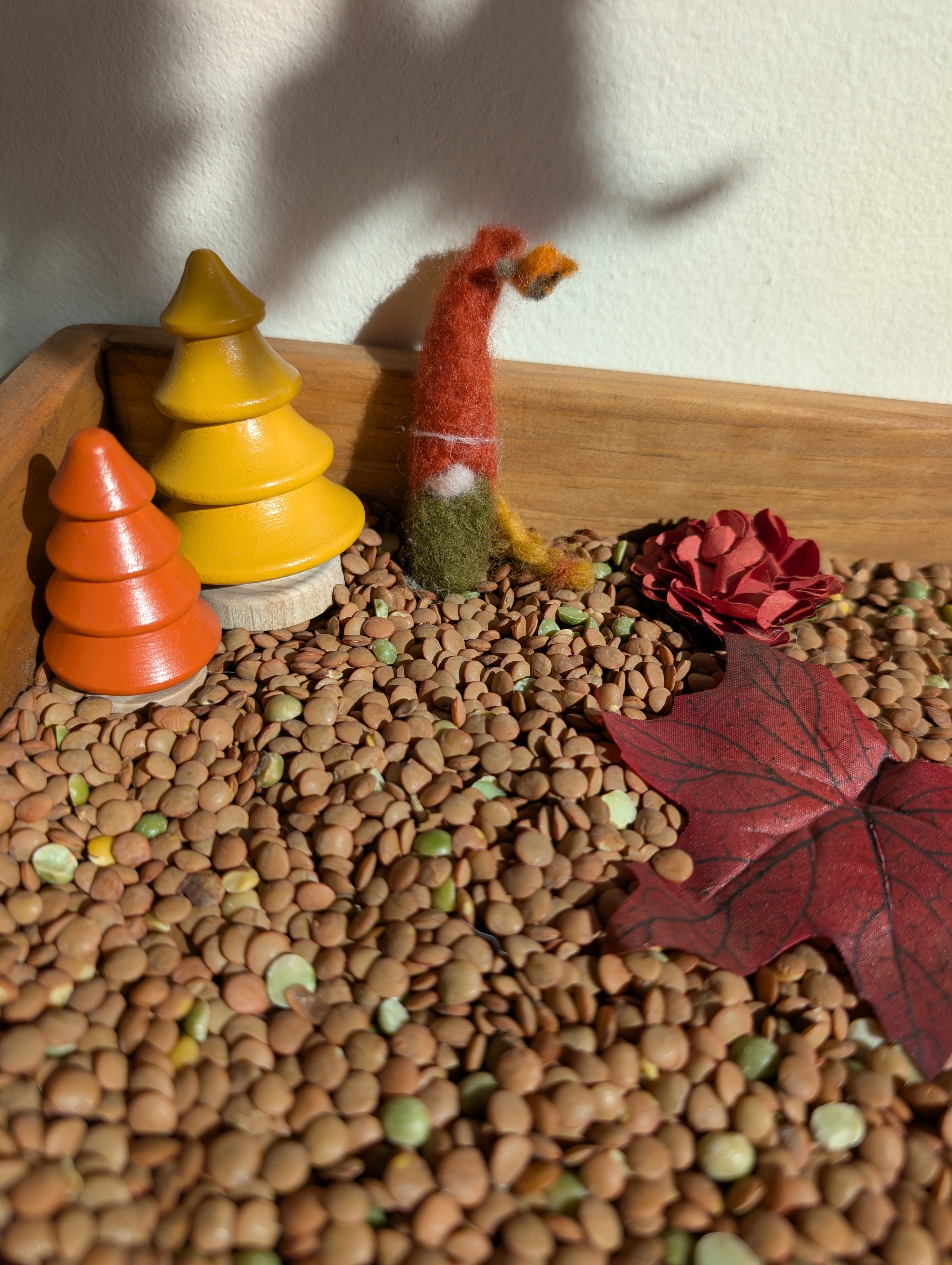 Needle felted gnome with a tall red hat and rosy cheeks